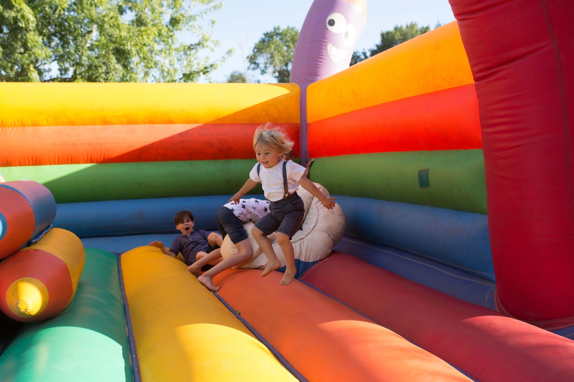Children, boys, playing jumping on colorful trampoline